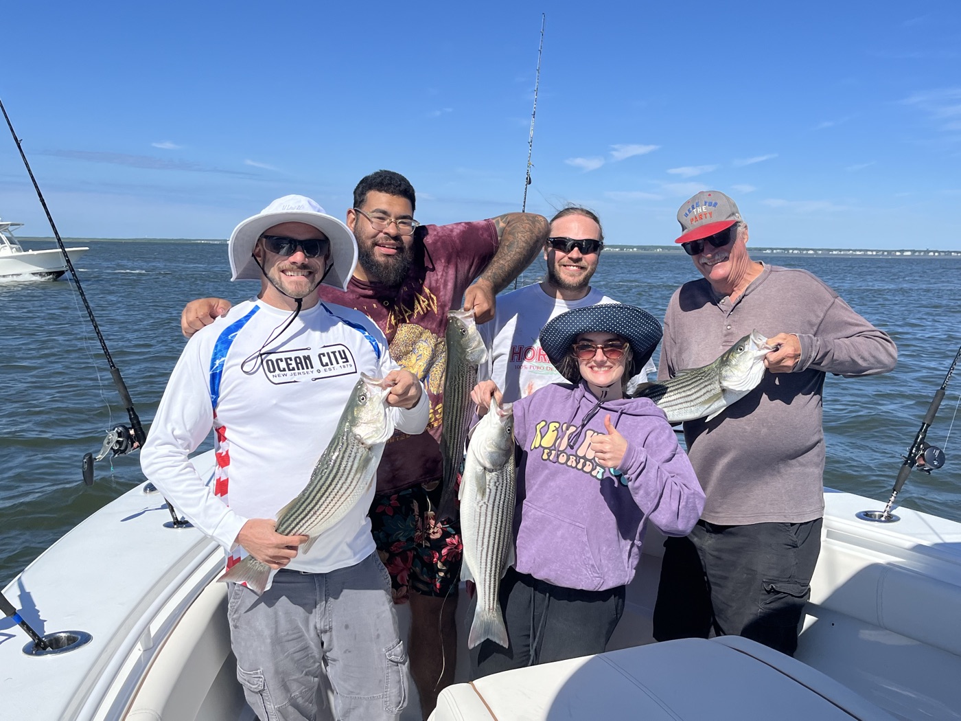 Family holding striped bass on the boat